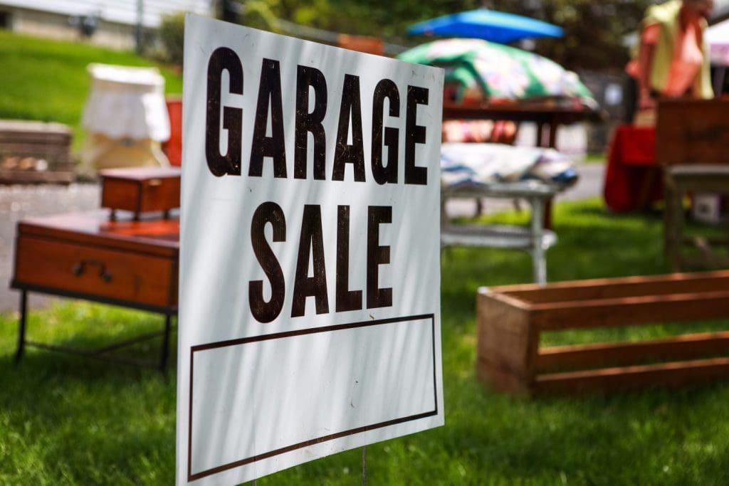 Garage,Sale,Sign,On,The,Shady,Lawn,Of,A,Suburban
